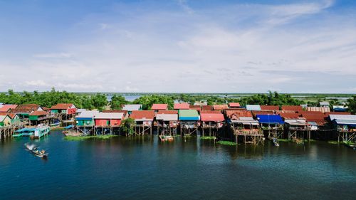 Free Scenic aerial view of colorful stilt houses on a river in Kampong Khleang, Cambodia, showcasing vibrant rural life. Stock Photo