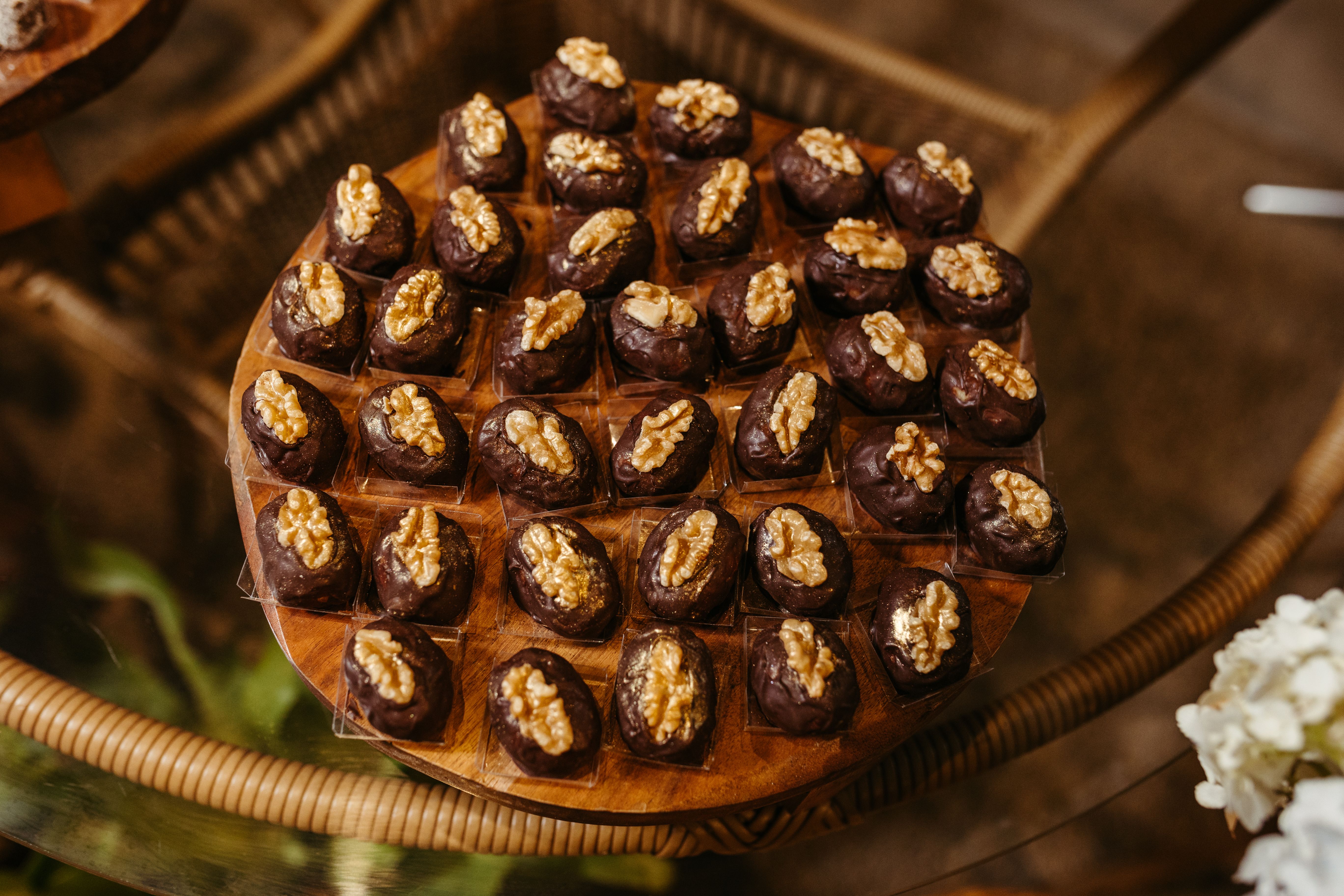 Free A tempting array of chocolate-covered date bites topped with walnuts on a wooden tray. Stock Photo