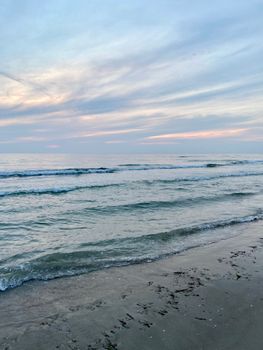 Gentle waves lapping against a quiet beach during a peaceful evening sunset at the ocean shore.