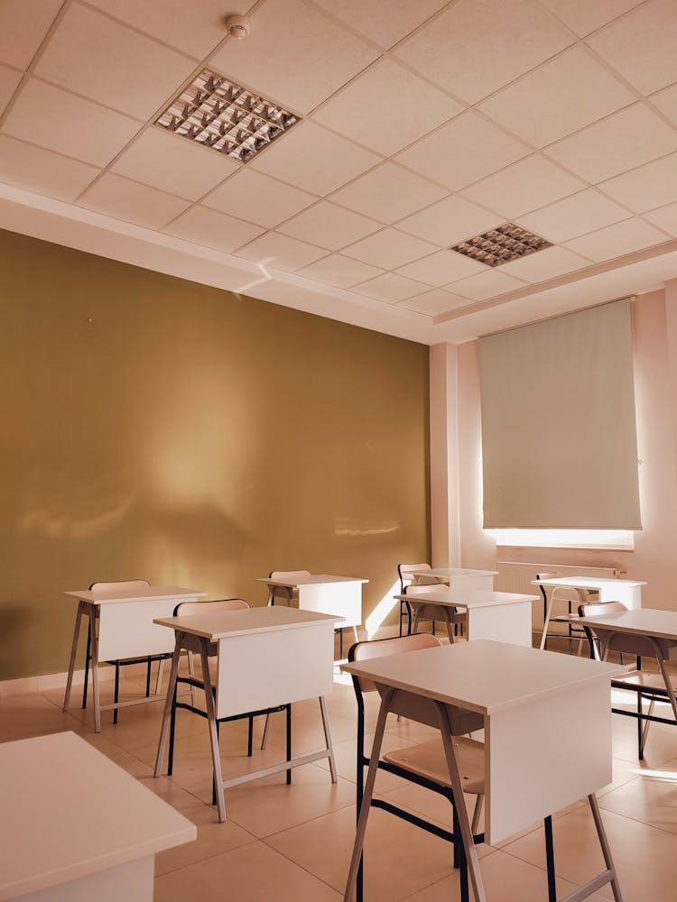 Empty Classroom With White Desks