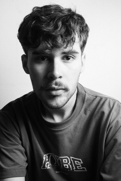 Free Close-up black and white portrait of a young man in a studio setting exhibiting a calm expression. Stock Photo