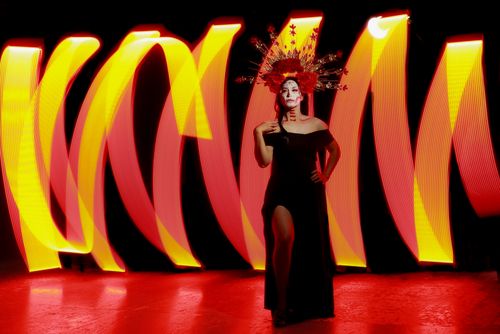 Free A woman in traditional Mexican attire and makeup stands in vibrant lighting, celebrating culture. Stock Photo