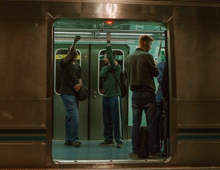 A group of people commuting on a subway train, showcasing urban public transportation.