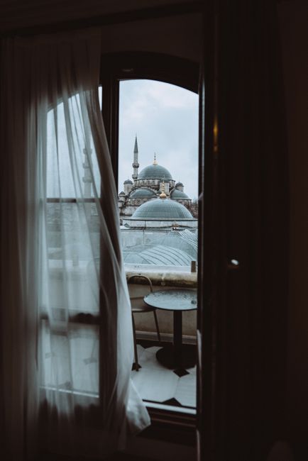 Atmospheric view of Istanbul mosque domes and minarets through a window.