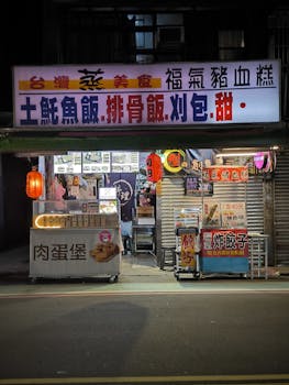 Colorful street food stall illuminated at night with traditional Tai cuisine signs