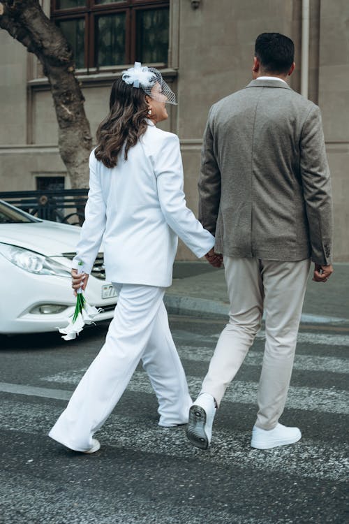 Newlyweds Holding Hands and Crossing Street
