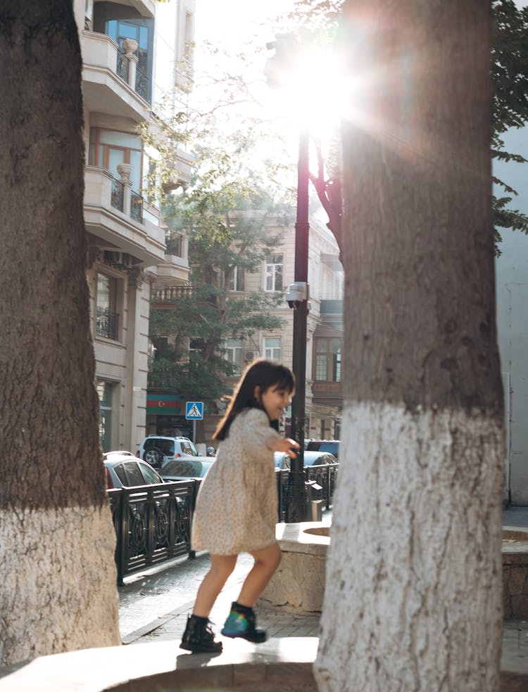 Little Girl Running Around The Tree