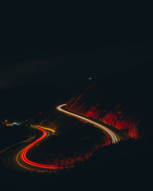 Free Curved mountain road with light streaks showing dynamic motion at night. Stock Photo