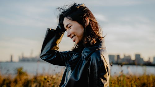 Smiling Asian Woman Posing near Seashore