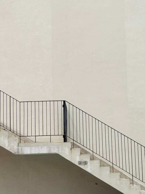 Free A minimalist concrete staircase with black handrails against a textured wall in Shenzhen, China. Stock Photo