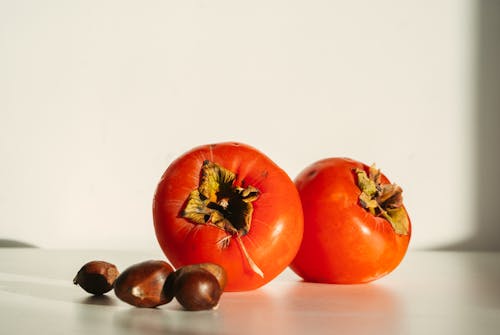 Chestnuts and Red Fruit on White Background