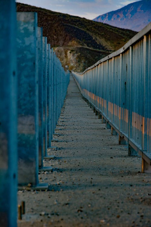 Suspension Bridge with Blue Railing in Mountains