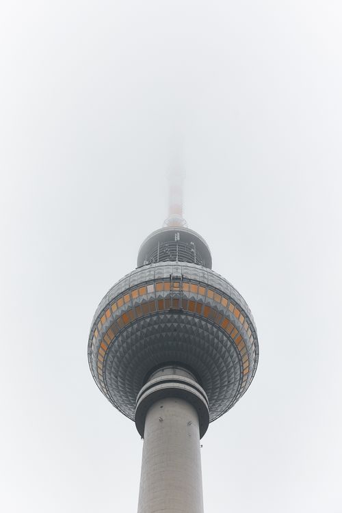 Free A vertical shot of Berlin's TV Tower enveloped in fog, creating a mysterious atmosphere. Stock Photo