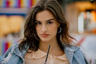 一位年轻女子穿着牛仔夹克，自信地看向镜头特写