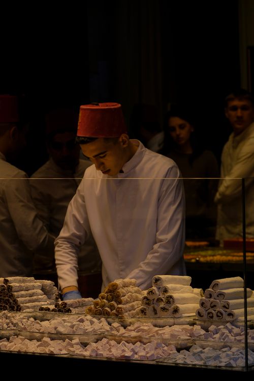 Free A vendor prepares traditional sweets at a confectionery stall. Perfect for cultural and culinary themes. Stock Photo