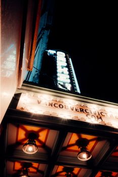 Dramatic low angle view of an illuminated theater sign on a Vancouver street at night.