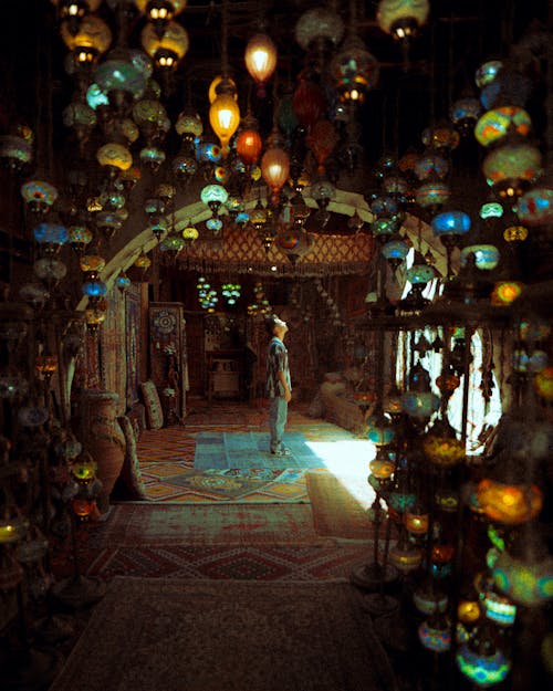Man Standing in a Room with Traditional Oriental Lamps 