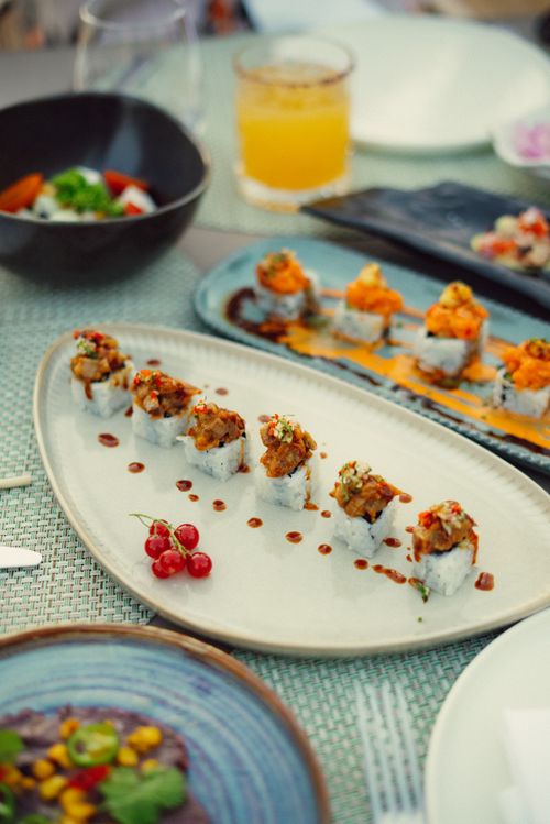 Free Delicious sushi rolls beautifully presented on ceramic plates in a refined dining setting. Stock Photo