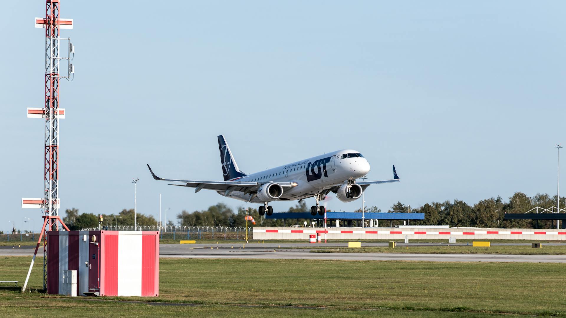 LOT Polish Airlines plane taking off from Prague airport on a clear day.