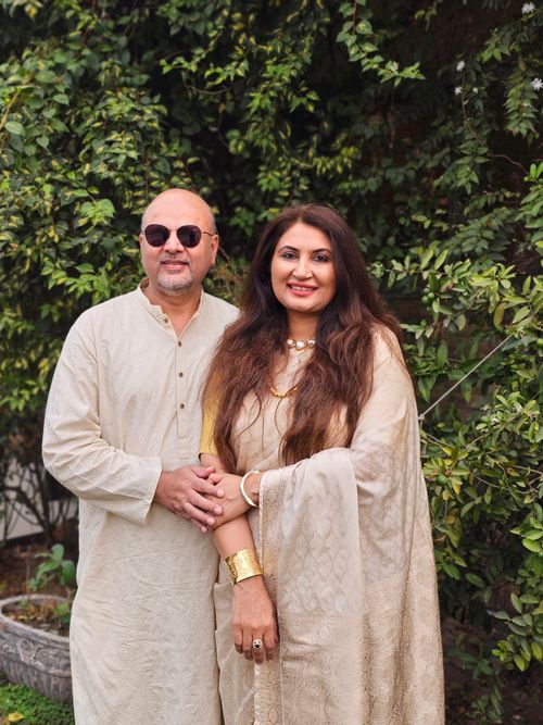 Free A stylish couple in traditional attire poses gracefully in a lush garden setting, exuding warmth and elegance. Stock Photo
