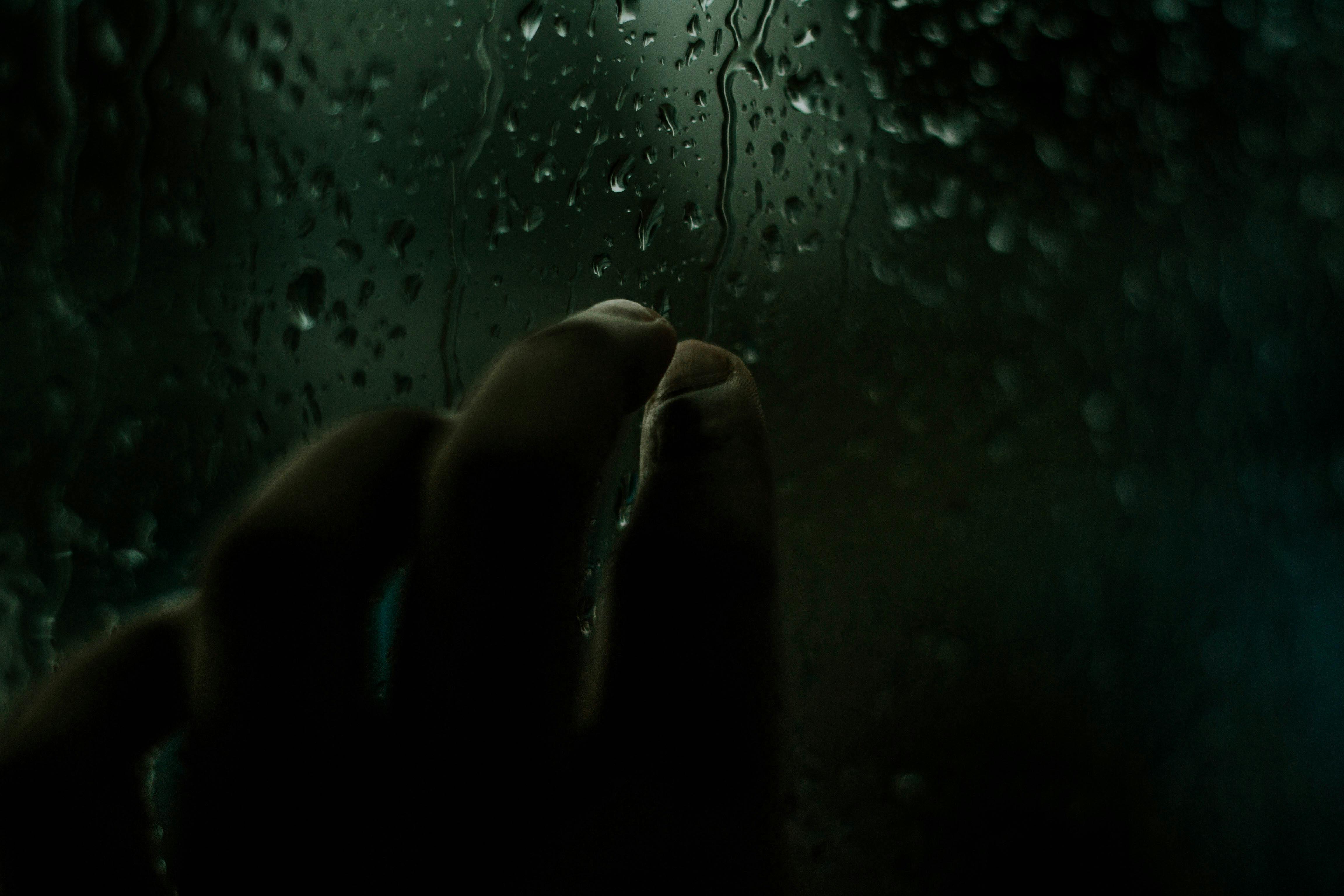 Person Touching Window With Dripping Water · Free Stock Photo