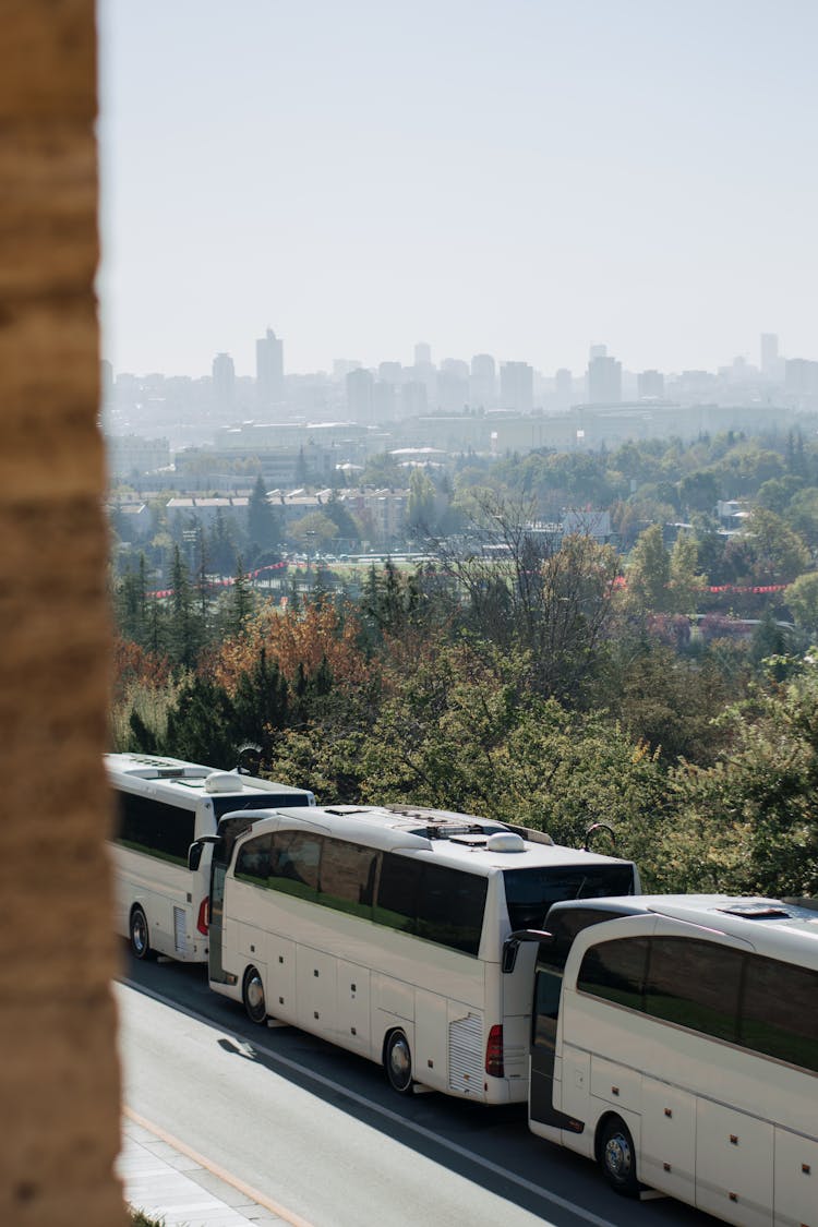 Coaches Parked On The Street On A Hill With The View Of The City 