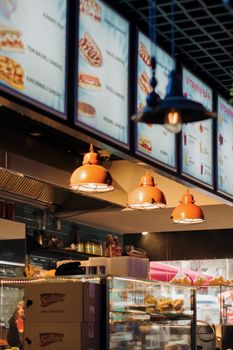 Warm bistro interior showcasing vibrant menu boards and ambient lighting for a cozy dining experience.
