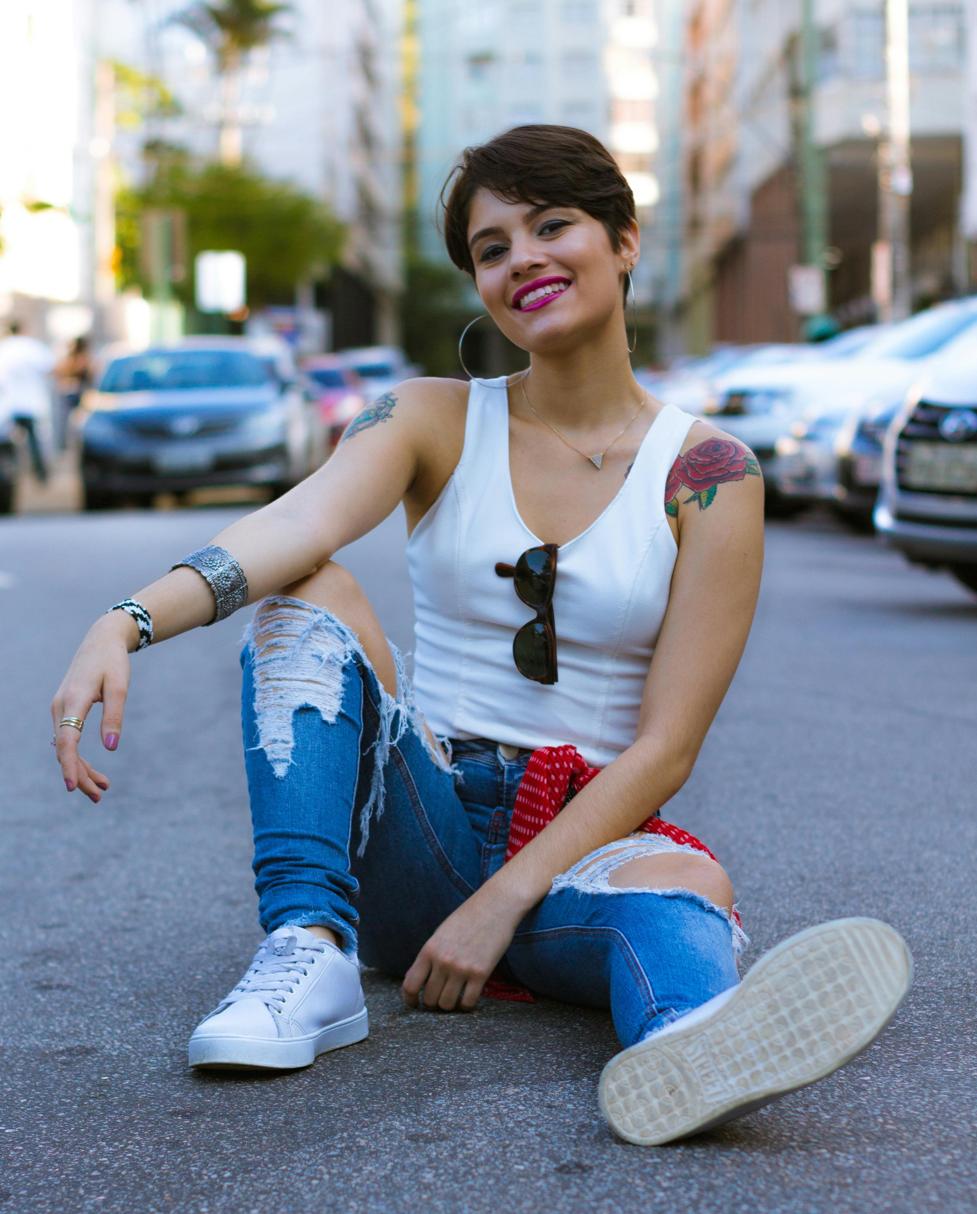 一位年轻女子坐在城市街道上，展现出时尚又充满活力的风格