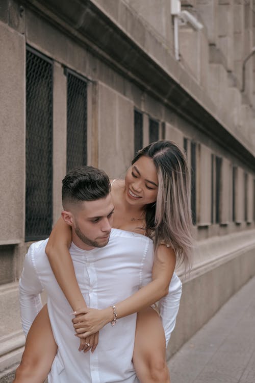 Smiling Woman Hugging Man in White Shirt