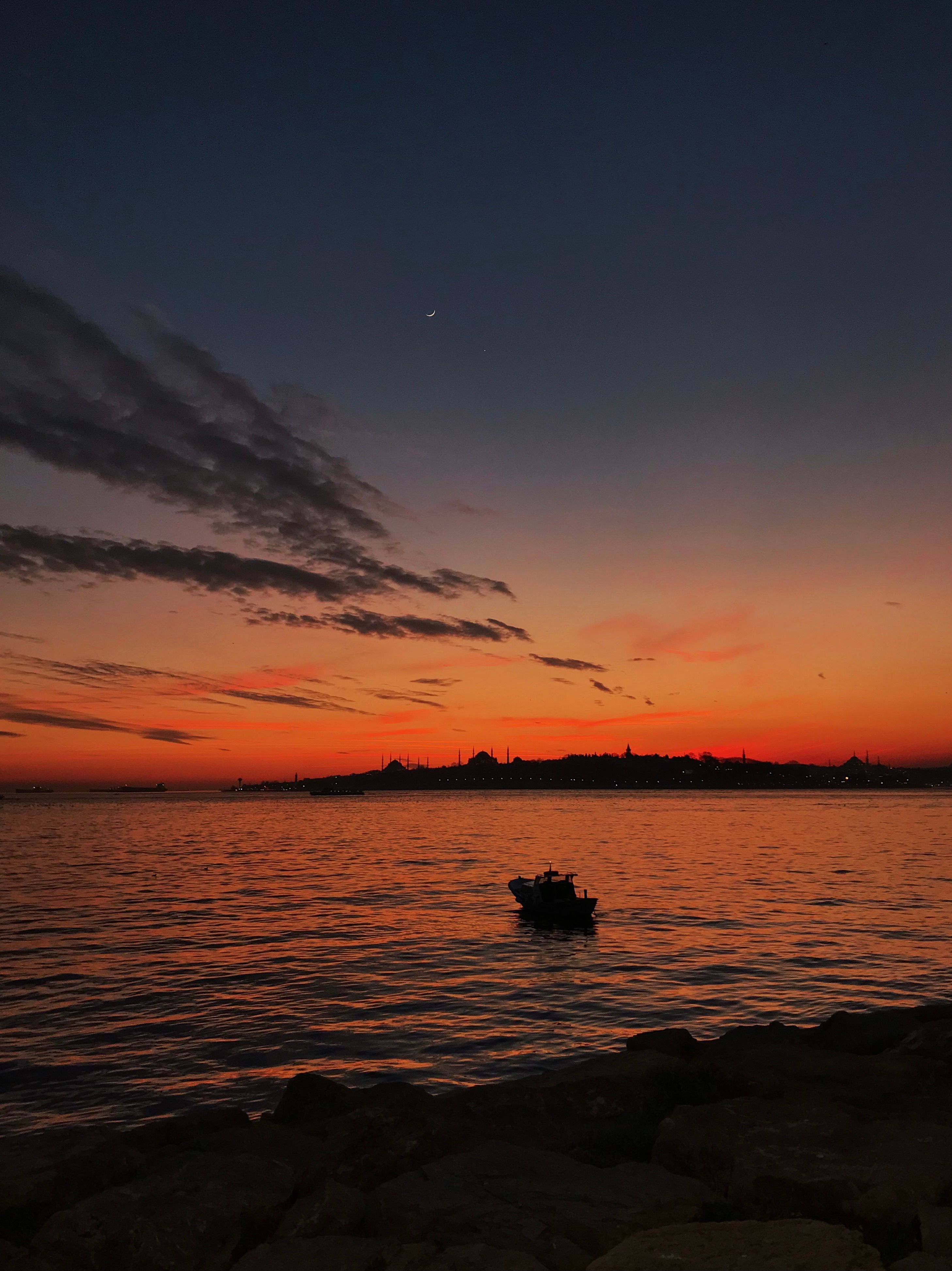 Skyline of a City seen from across the Water at Sunset · Free Stock Photo