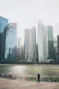 前景只有一个人，新加坡标志性现代摩天大楼的海滨景观显得格外宁静