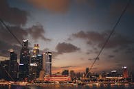 黄昏时分，新加坡的天际线壮丽非凡，摩天大楼的灯光映照在水面上