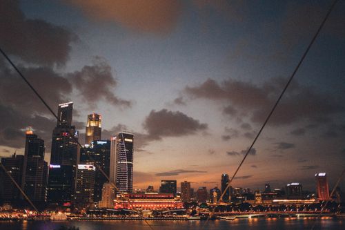 Free Stunning view of Singapore's skyline at dusk with illuminated skyscrapers reflected on water. Stock Photo