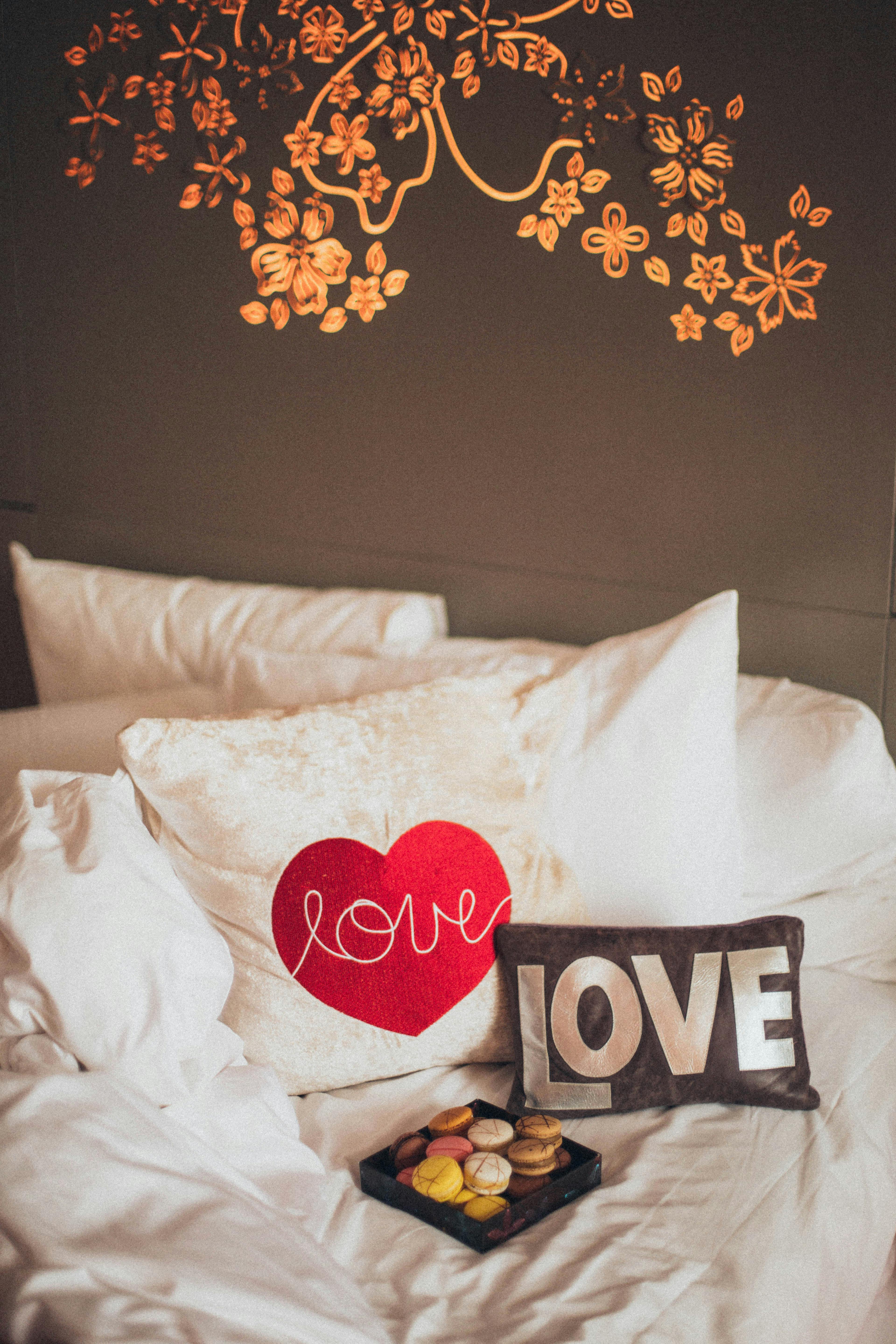 卧室环境舒适，配有装饰性的爱情主题枕头和浪漫的墙壁设计