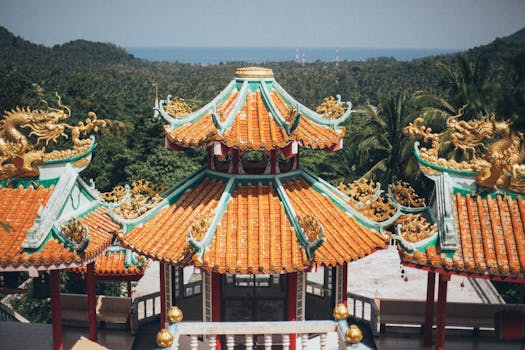 风景如画的亚洲寺庙屋顶华丽，绿树成荫，背景是海洋