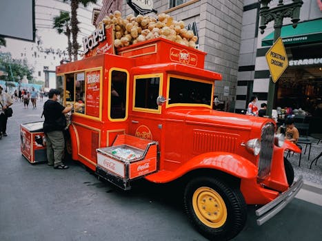 Colorful vintage popcorn truck serving snacks on urban city street.