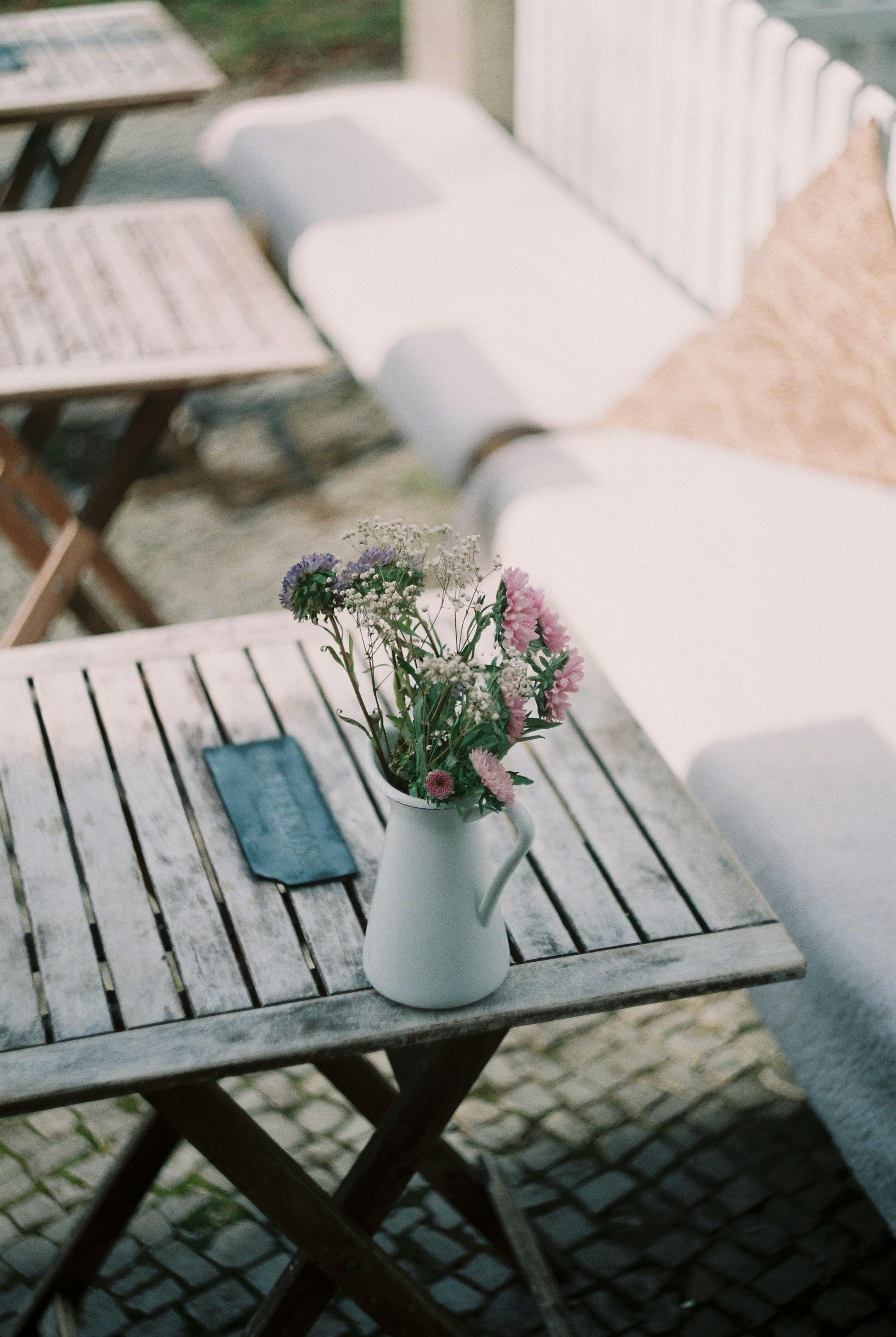 Charming rustic café scene featuring a floral arrangement in a vase on a wooden table.