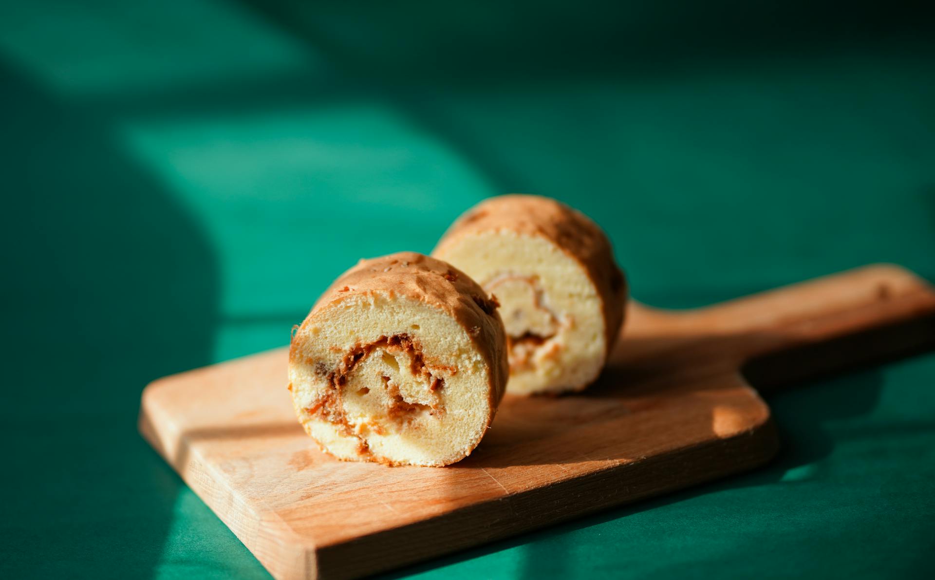 Close-up of a tasty roll cake on a chopping board, perfect dessert image.