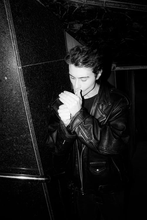 Man Wearing Leather Jacket Smoking a Cigarette in Black and White