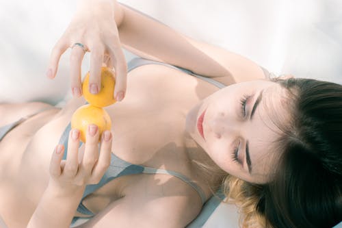 Woman Wearing Swimsuit Holding Lemons 