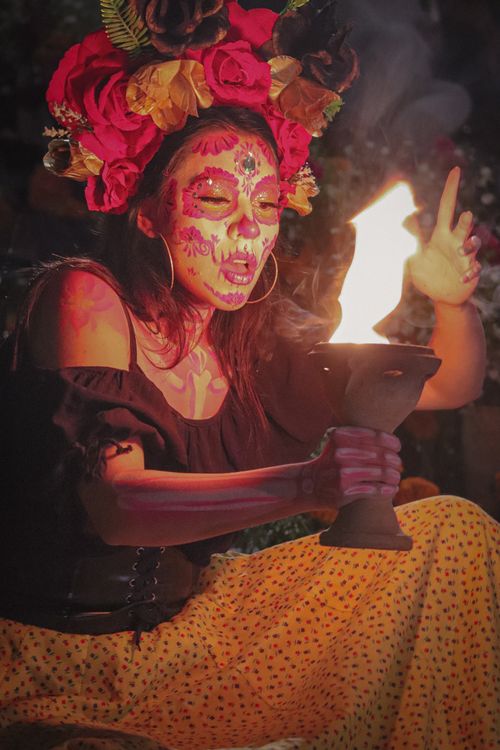 Free A woman in Catrina makeup celebrates Dia de Muertos with a fiery display in Mexico City. Stock Photo