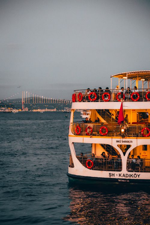 Free A ferry on the Bosphorus at sunset with Istanbul's skyline, showcasing iconic Turkish transportation. Stock Photo