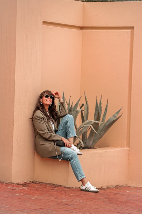 Smiling Woman Sitting by Agave in City