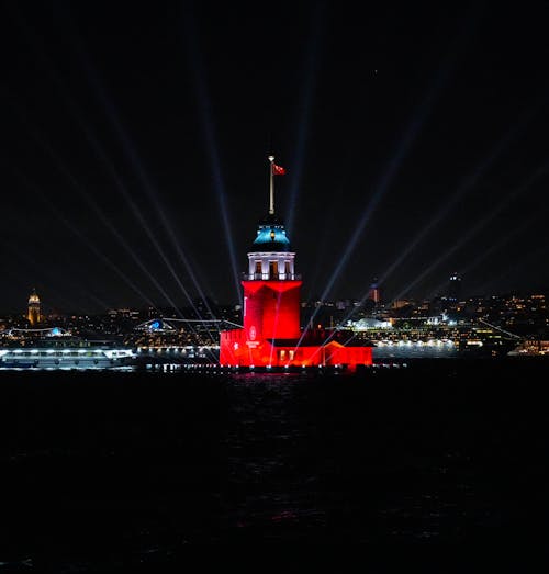 Free Dramatic night view of the illuminated Maiden Tower in Istanbul, Turkey, glowing red against the skyline. Stock Photo