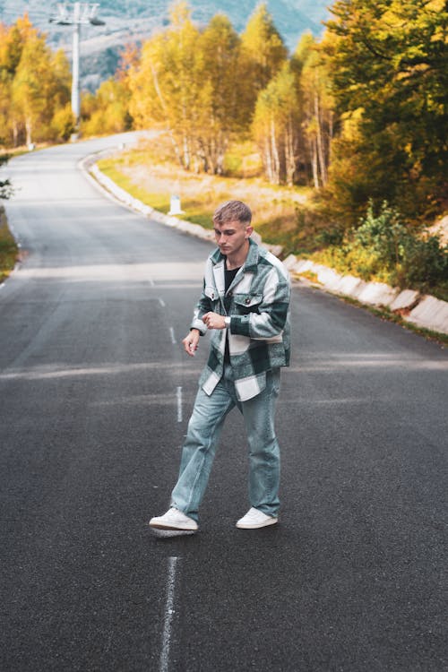 Young Man in Jacket Standing in Middle of Road