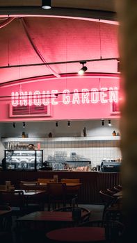 Chic café setting featuring a bright neon sign and modern furniture, creating a vibrant atmosphere.