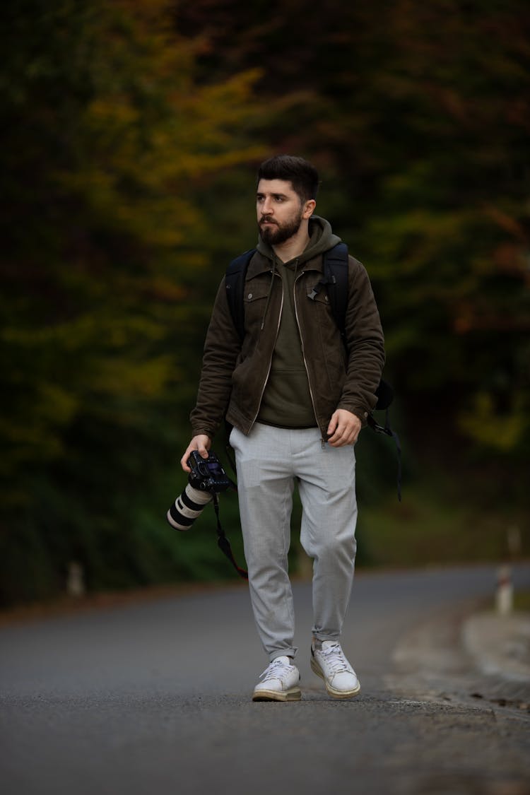 Man On Walk Holding Digital Camera In Hand