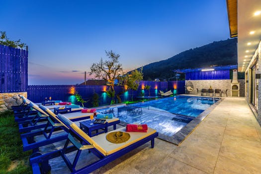 Elegant villa with a modern pool and deckchairs, perfect for a relaxing evening getaway.
