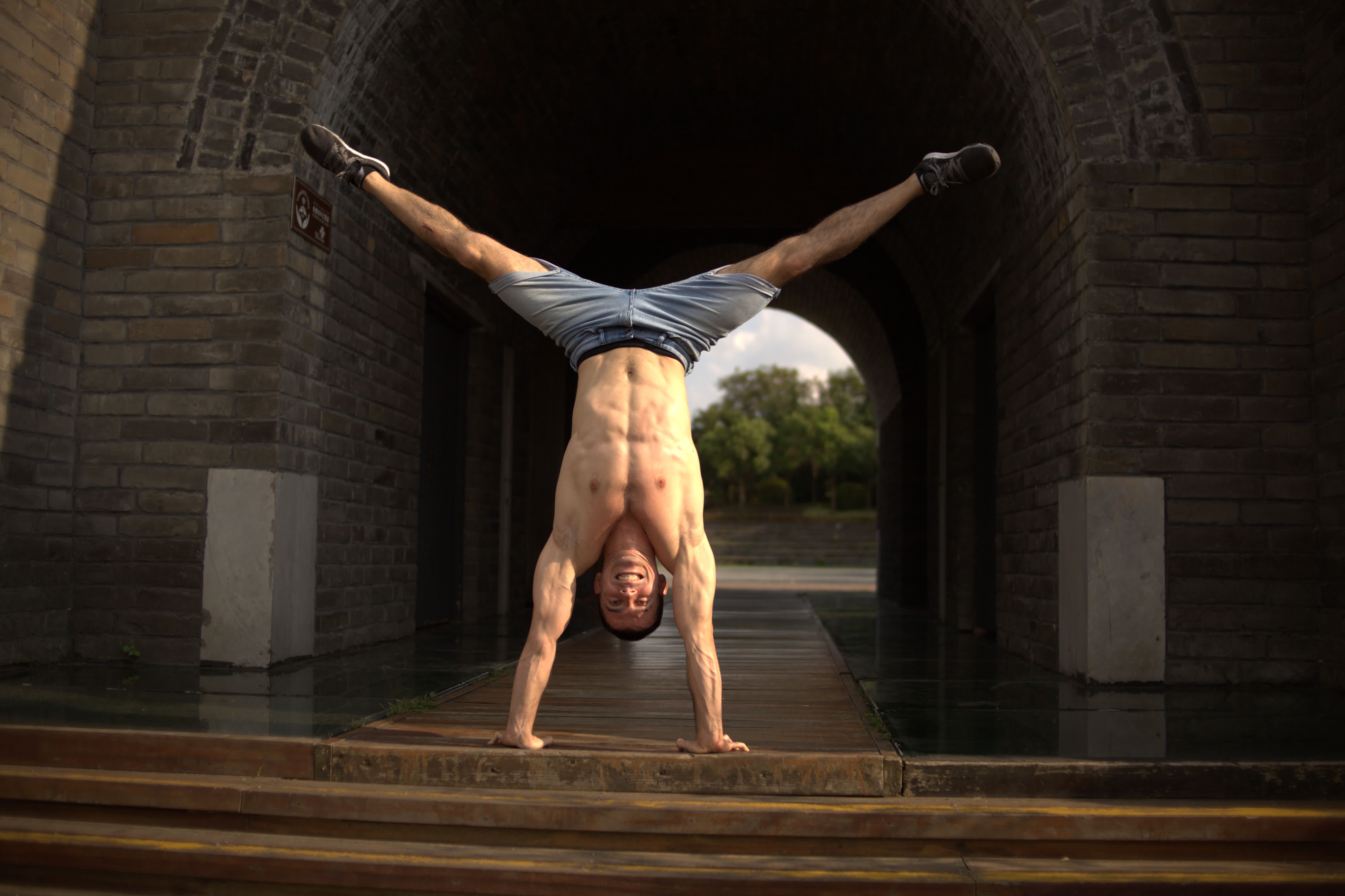 Smiling Acrobat Doing the Splits while Handstand · Free Stock Photo