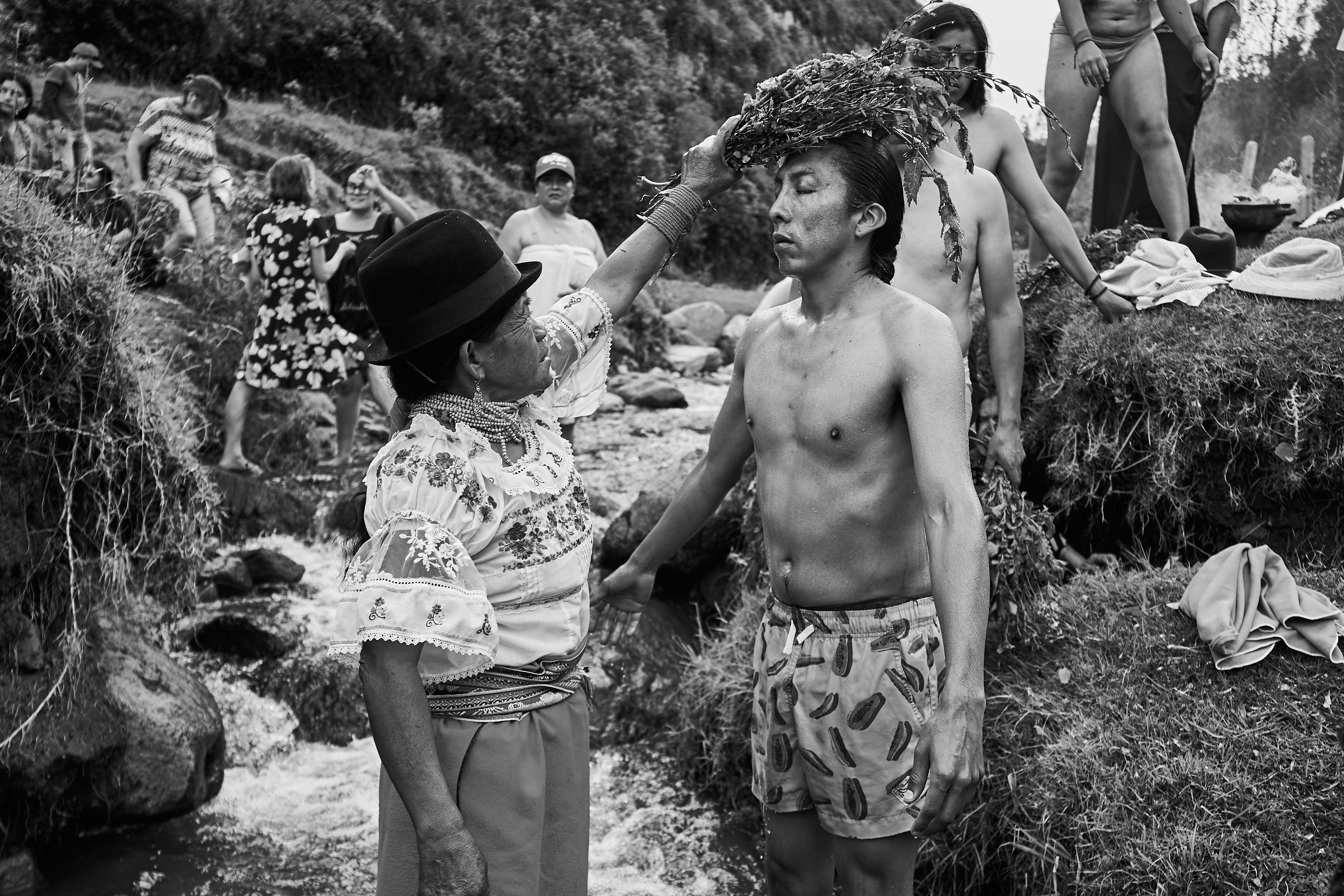 man standing in stream during traditional ceremony